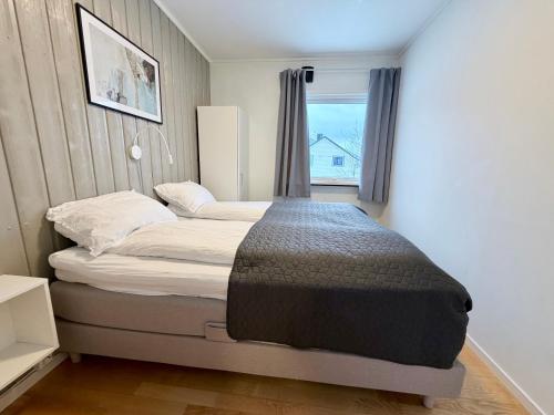 a bed in a small room with a window at apartment With fantastic view and parking in Tromsø