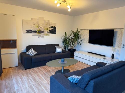 a living room with two couches and a flat screen tv at 95qm Wohnung für 6, 3 Schlafzimmer, ruhig & stadtnah, Parkplatz in Bad Hersfeld