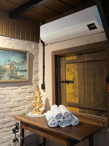 a room with a table with towels and a door at Casa Sabia com charme rústico e belos jardins in Benedito Novo