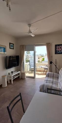 a bedroom with a bed and a television and a patio at Green Bay Beach Escape in Protaras