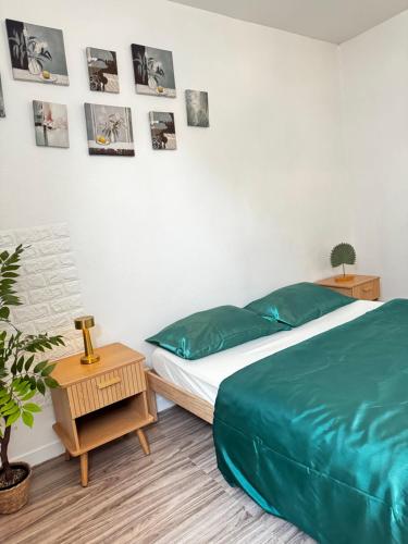 a bedroom with a bed and a table and pictures on the wall at greenhouse home in Corbeil-Essonnes