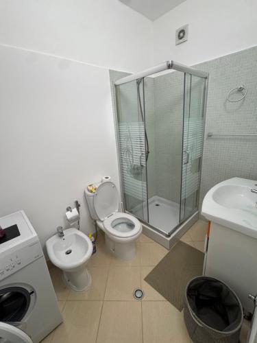 a bathroom with a shower and a toilet and a sink at Teddy Apartment in Durrës