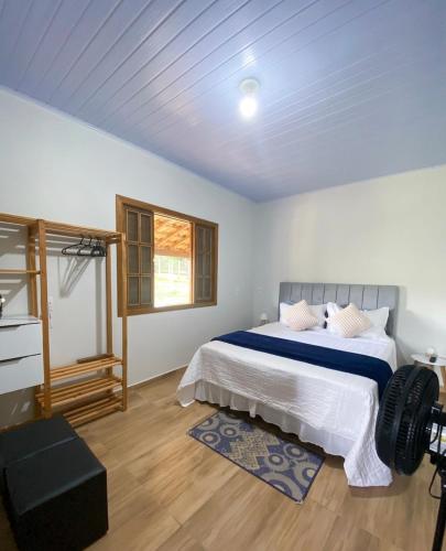 a bedroom with a large bed and a window at Sítio Anna in São Thomé das Letras