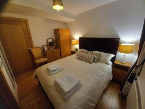 a bedroom with a large bed with two towels on it at Teach Sile in Kiltimagh