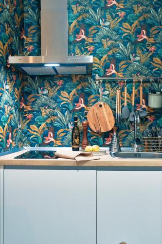 a kitchen counter with a wallpaper with birds on it at Casa Vestali in Granada