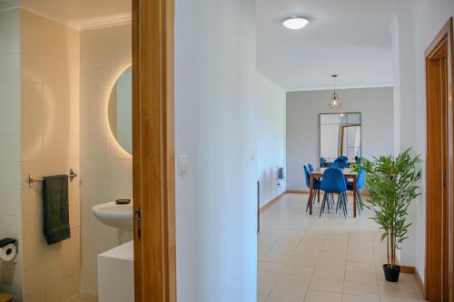 a kitchen and dining room with a table and blue chairs at Azorina Lodge in Ponta Delgada