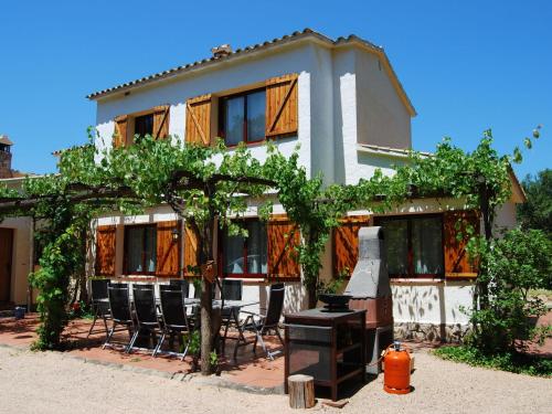 a house with a bunch of chairs and a table at Belvilla by OYO Vall Repos in Calonge