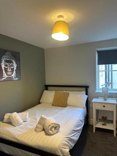 a bedroom with a bed with two pillows on it at Maple House by ShortStays4U A beautiful 2Bedroom House with free parking in town centre! in King's Lynn