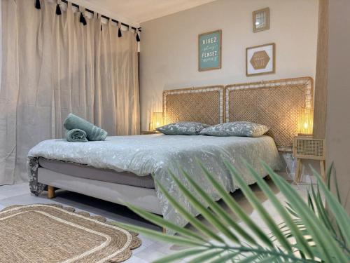 a bedroom with a bed with blue pillows and a plant at Studio indépendant a 20min des plages in Castelnau-de-Guers
