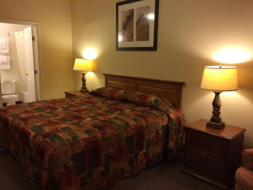 a hotel room with a bed and two lamps at Country Regency Inn & Suites in Manvel