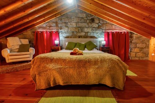 a bedroom with a bed with a teddy bear on it at Entre a Pedra e o Mar in Faial da Terra