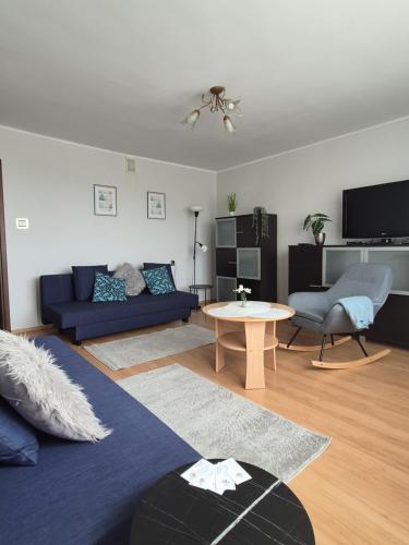 a living room with a blue couch and a table at Apartament nad Nidą in Sobków
