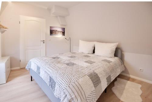 a bedroom with a bed with a quilt on it at Sehr gemütlich und modern in Haldensleben