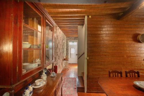 a dining room with a table and a wooden wall at Entre a Pedra e o Mar in Faial da Terra