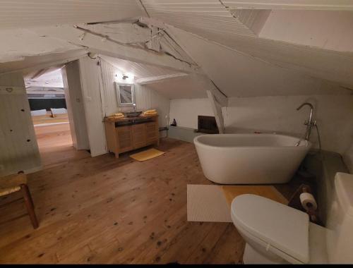 a bathroom with a white tub in a attic at La Maison d'ART in Lacour