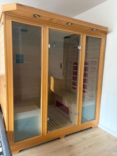 a wooden cabinet with glass doors in a room at Fewo Seestern in Neukieritzsch