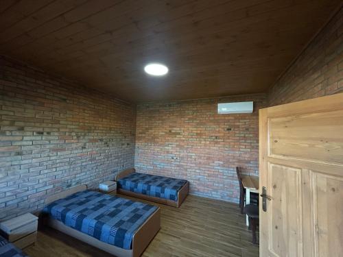 a room with two beds and a brick wall at Hotel Eliot in Łomża