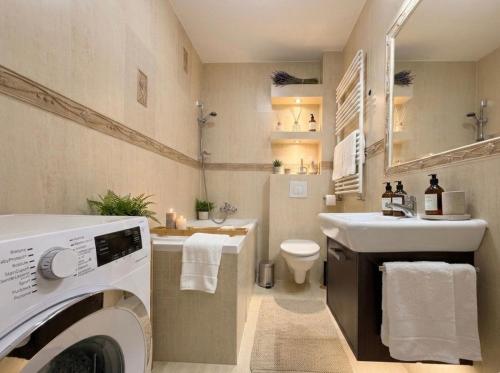 a bathroom with a washing machine and a sink at Gustowny apartament in Inowrocław
