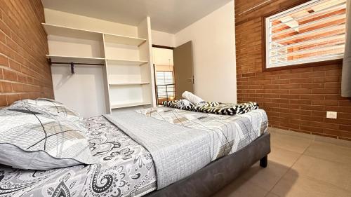 a bedroom with a bed and a brick wall at Rio - Destination Guyane in Macouria