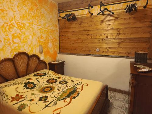 a bedroom with a bed and a wooden wall at Ca' della Sfinge Colibrì a Civiasco in Varallo