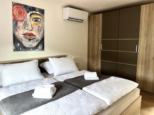 a bedroom with a large bed with a painting on the wall at Apple & Pear in Ročinj
