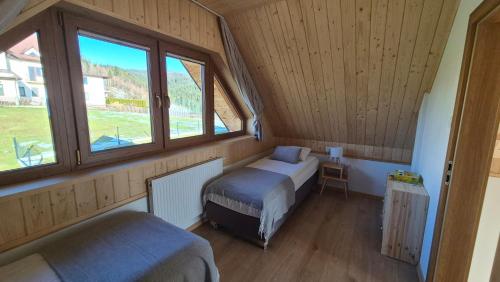 a small bedroom with a bed and a window at Domki na Wymyślu in Grywałd