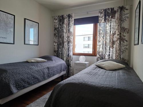 a bedroom with two beds and a window at Elice Apartment in Rovaniemi