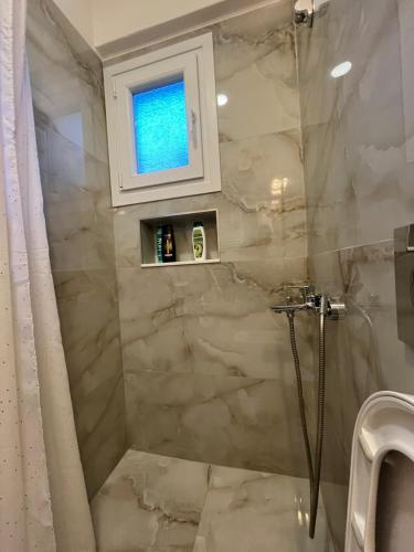 a bathroom with a shower with a glass door at Κομψό studio με δωρεάν πάρκινγκ in Volos