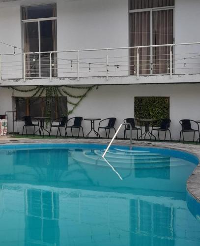 a swimming pool with chairs and a table in a building at the silva house in Huacachina