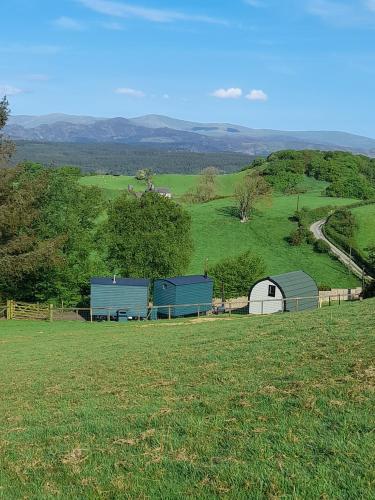 a field with two barns on a hill at Siabod Huts in Betws-y-coed