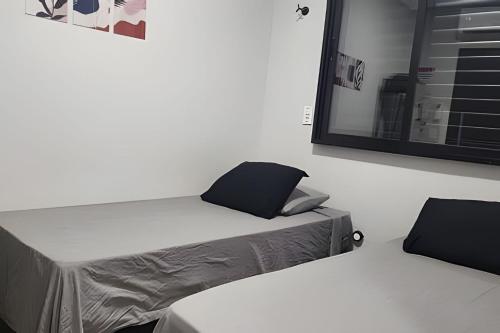 a white room with a bed and a mirror at Studio V - Com Ar Condicionado in Jundiaí
