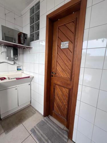 a kitchen with a wooden door and a sink at Alugo quarto com internet in Porto Alegre