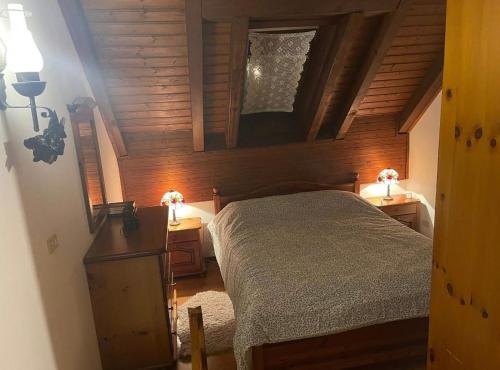 a bedroom with a bed and two tables with lamps at Erika in Tarvisio