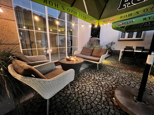 a patio with chairs and a table and an umbrella at Hotel Nowy Dwór in Trzebnica
