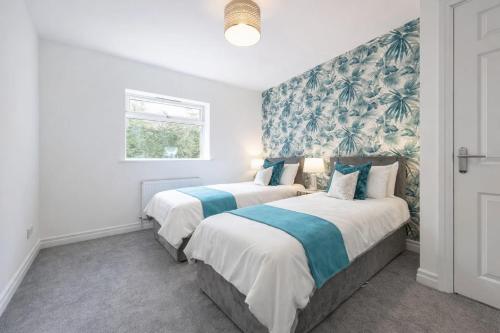 two beds in a room with white walls at Large 2-Bedroom Bungalow near Airedale Hospital, Keighley, Convenient Location with Parking in Steeton