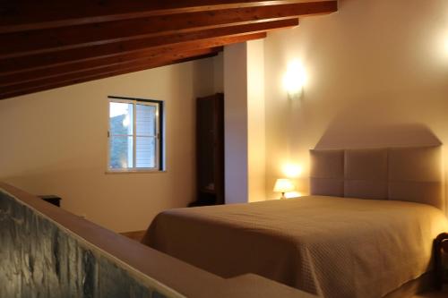 a bedroom with a bed and a window at Montes da Barca in Aldeia Nova do Concelho