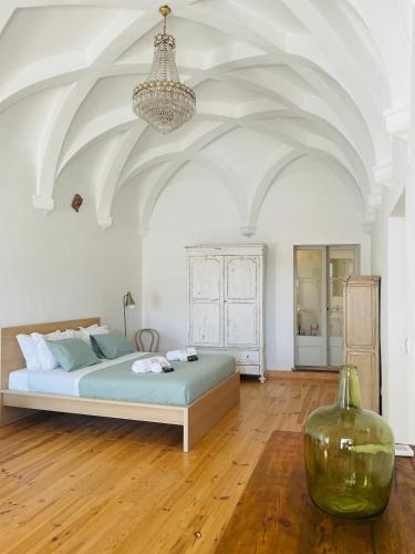 a bedroom with a bed and a vase on the floor at Cosmogama House in Évora