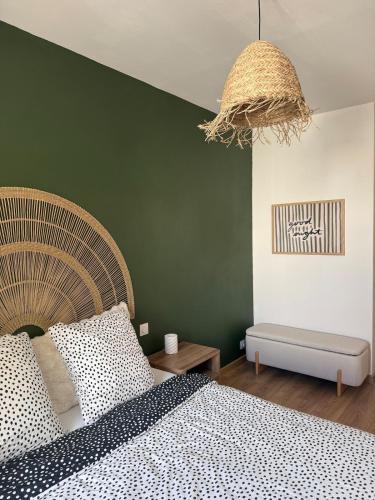 a bedroom with a bed and a green wall at La Mandarouseraie in Millau