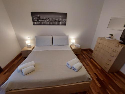 a bedroom with a large white bed with two night stands at Gelsy House in Montecchio Maggiore