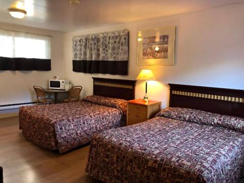 a hotel room with two beds and a table at Marland Motel in Powell River