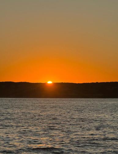 un coucher de soleil sur une étendue d'eau dans l'établissement Villa Bompas 66, à Bompas