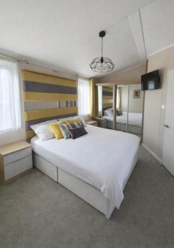 a bedroom with a large white bed and a television at The View Point Northumberland in Newton on the Moor