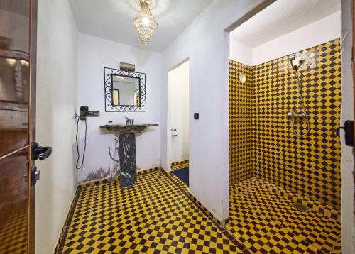 a bathroom with a black and yellow checkered floor at kasbah boutique mamouche in Adrouine