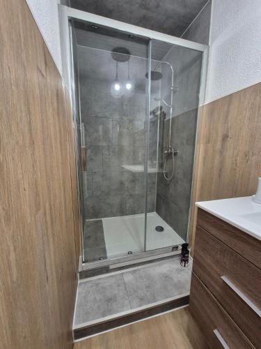 une douche avec une porte en verre dans une salle de bain dans l'établissement meze34, à Mèze