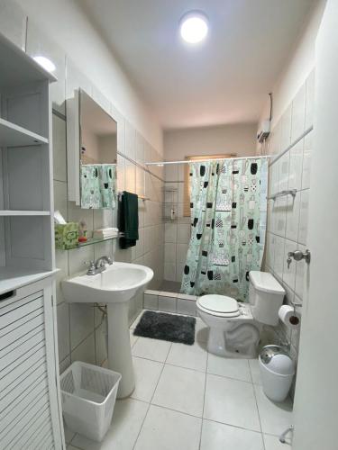 a bathroom with a sink and a toilet and a shower at Aruba Villa on a Hill in Savaneta