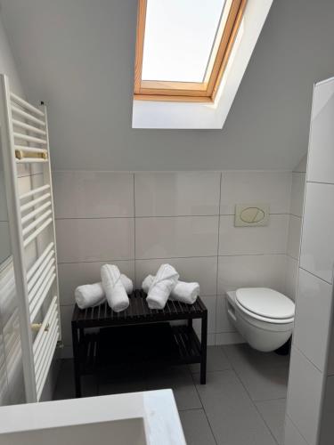 a bathroom with a toilet and a table with towels at B&B Bodegem in Dilbeek