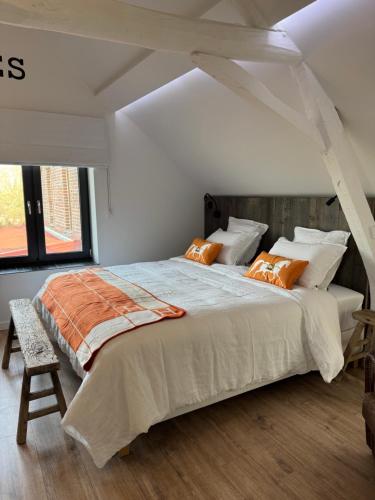 a bedroom with a large bed with orange pillows at B&B Bodegem in Dilbeek