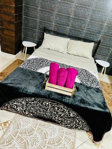 a bed with two pink pillows on it at DiMarS in Megara