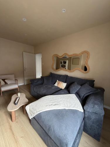 a bedroom with a bed and a couch and a mirror at Lindomptable love room in Méricourt