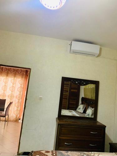 Um quarto com espelho e cômoda com ventilador. em TerraNova IMMO em Mbour